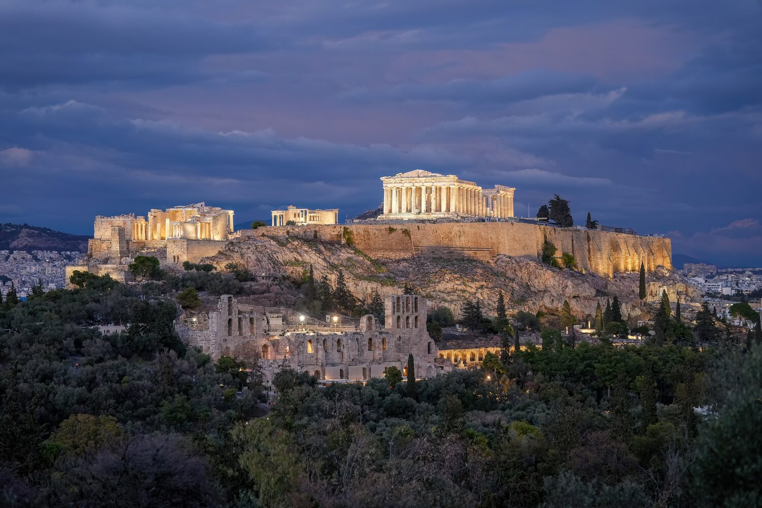 The Parthenon atop the Acropolis hill overlooking the city of Athens at sunset
