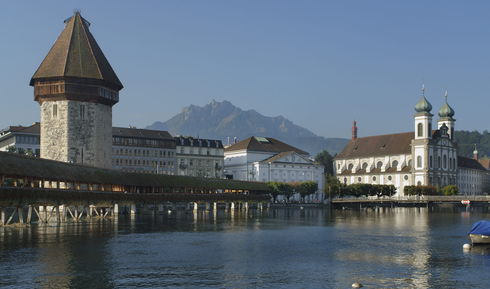 Lucerne's Chapel Bridge and Water Tower spanning the Reuss river with Mount Pilatus in the background