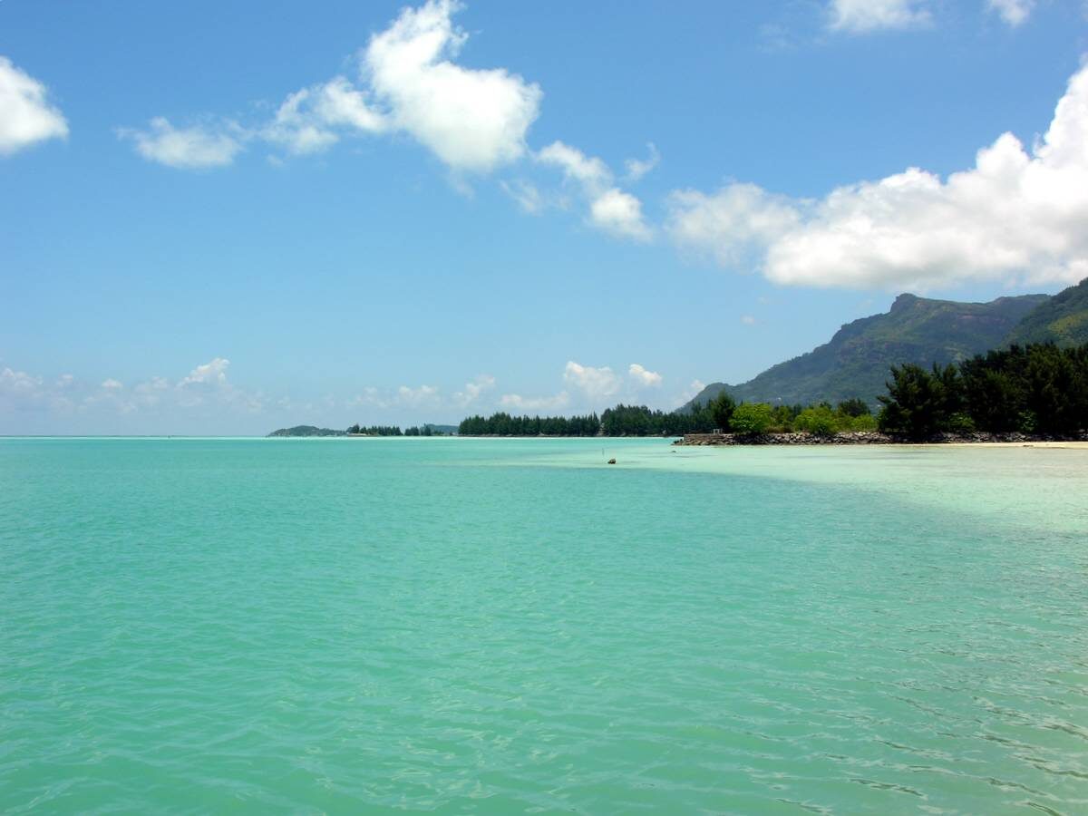 Lush green mountains and a turquoise bay on Mahé island in the Seychelles