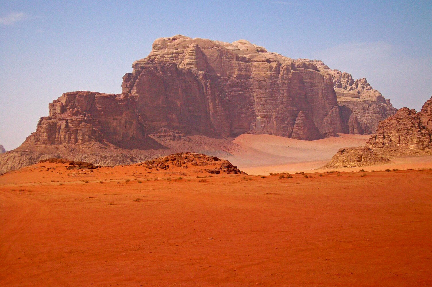 Red sandstone mountains rising from the desert floor at Wadi Rum, Jordan