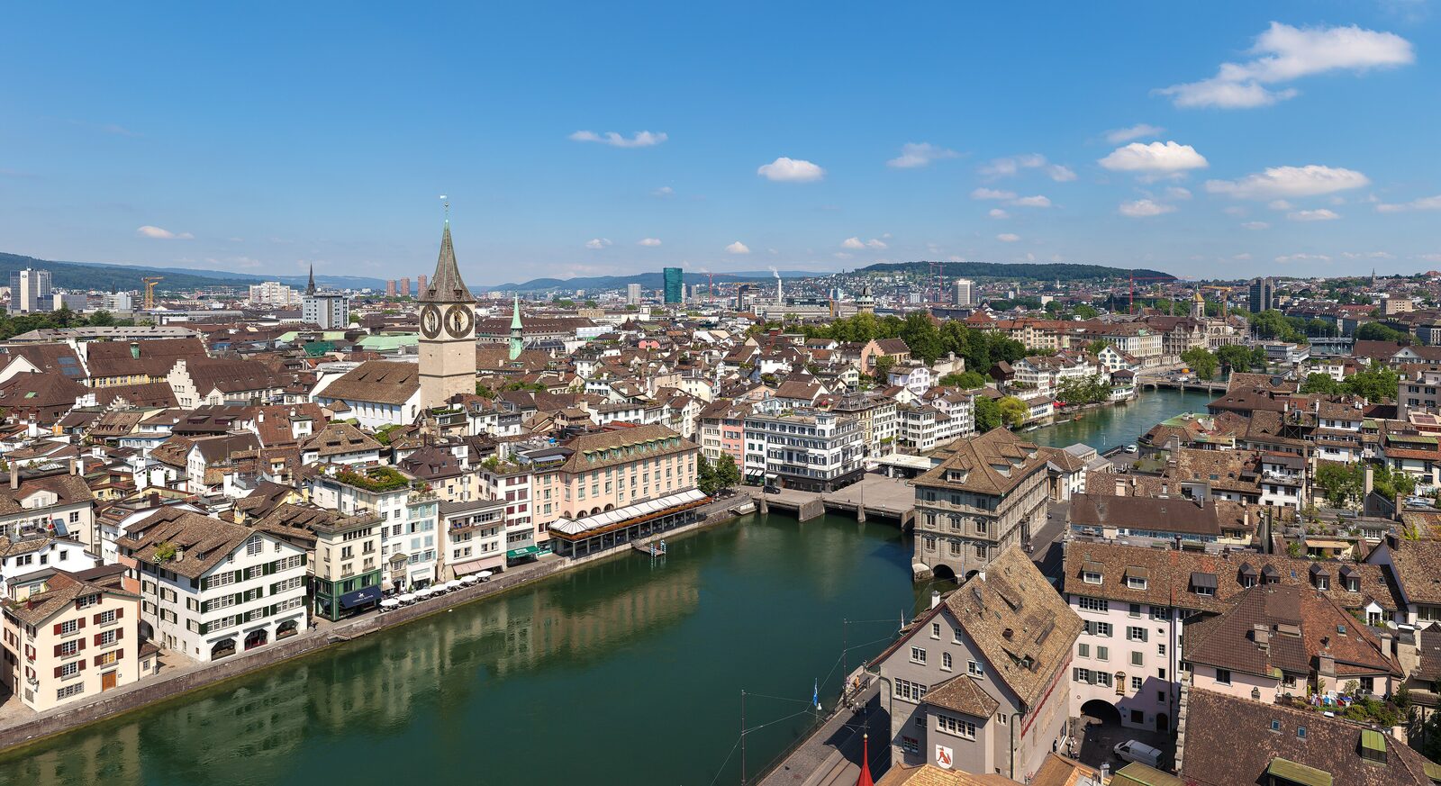 The old town of Zurich with its twin-towered Grossmünster church reflected in the Limmat river